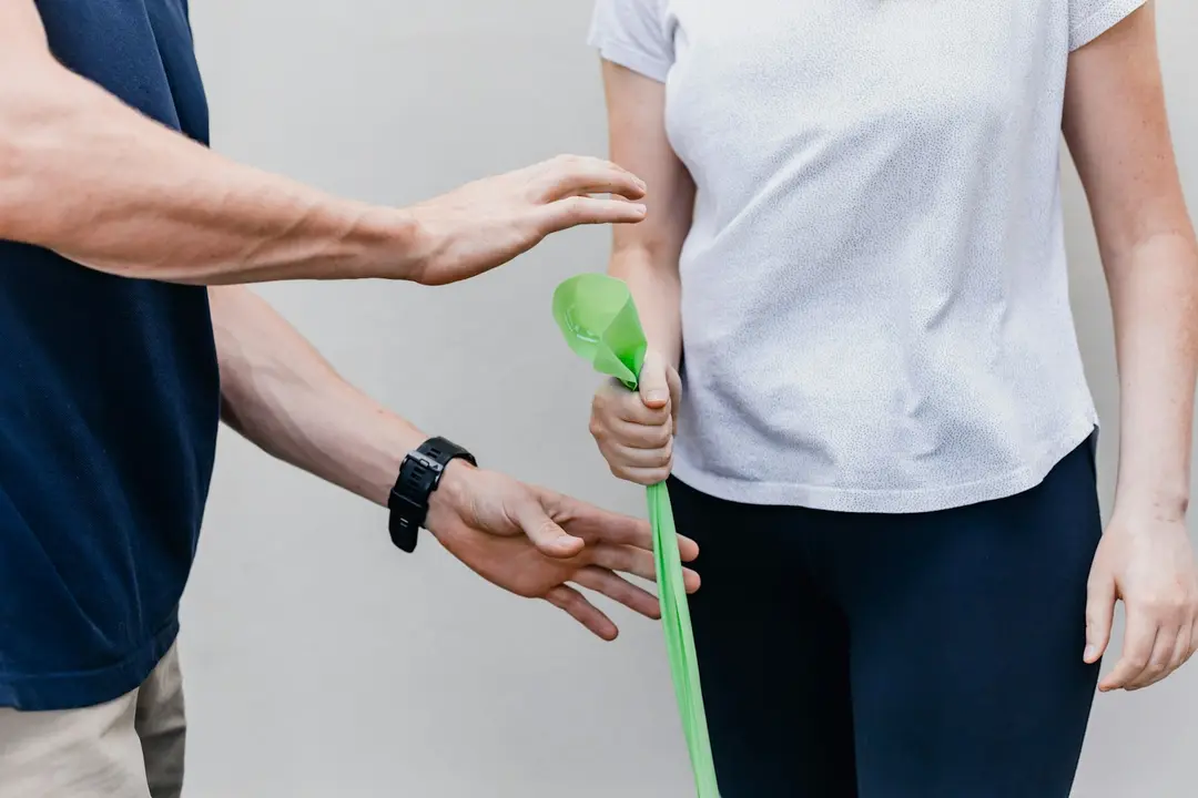 Therapist guiding a patient’s exercise with a resistance band