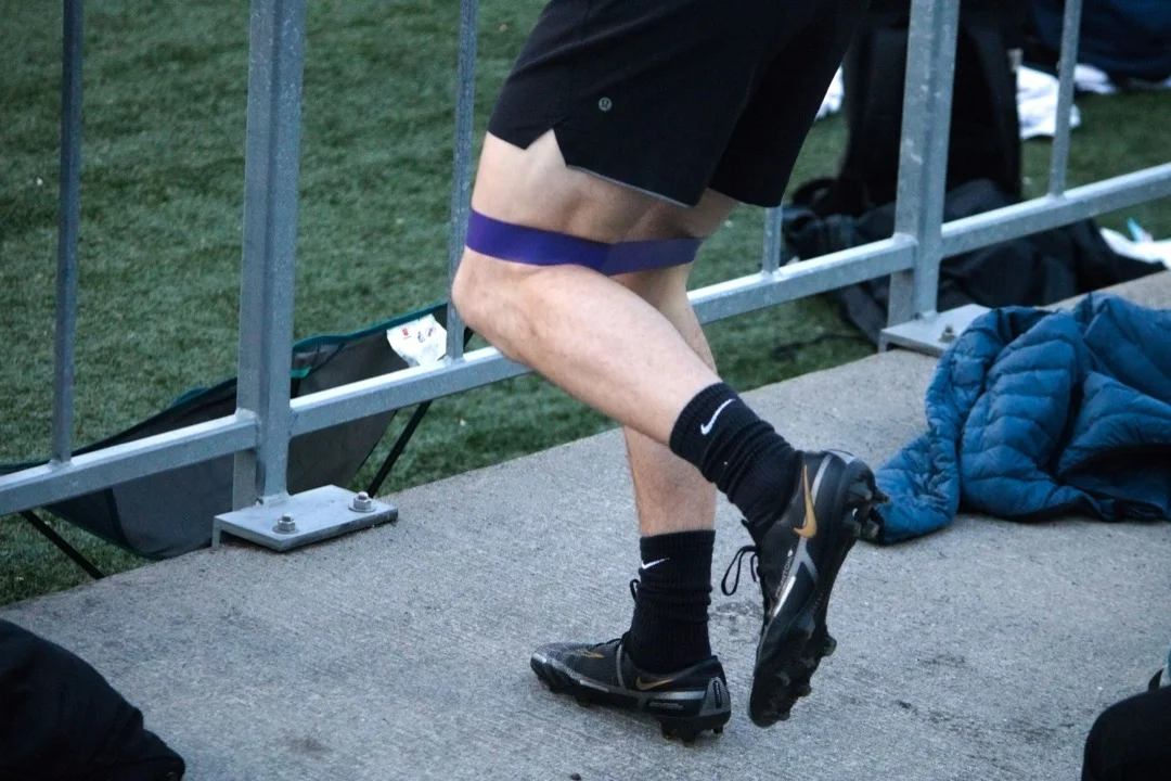 Athlete using a resistance band for a guided warm-up before returning to sport